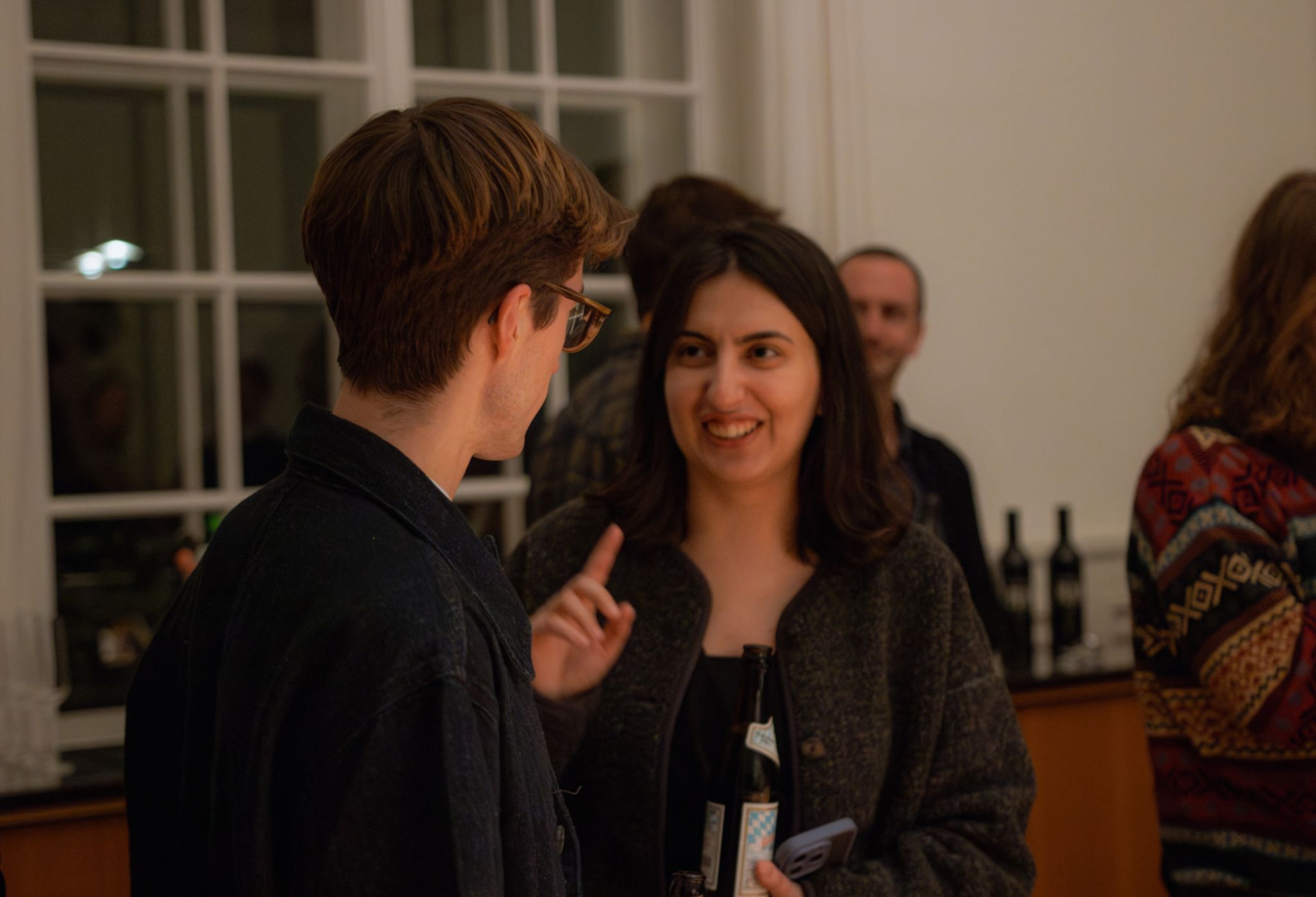 David listening to someone speaking at an informal evening gathering